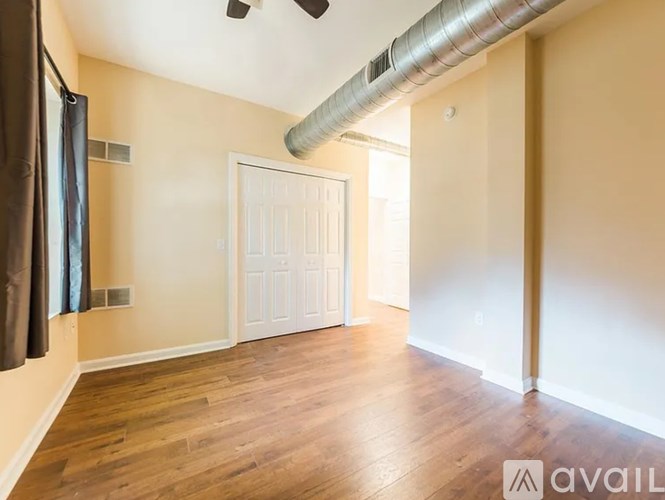 A room with a white door and a wooden floor.