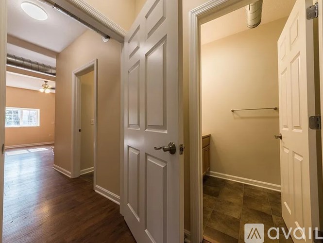 A hallway with white doors and a wooden floor.