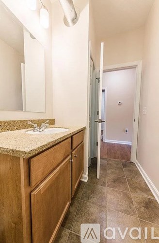 A bathroom with a sink, mirror, and wooden cabinets.