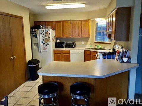 A kitchen with a white counter top and wooden cabinets.