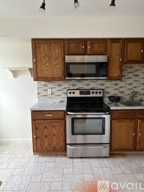 A kitchen with wooden cabinets and a granite countertop.