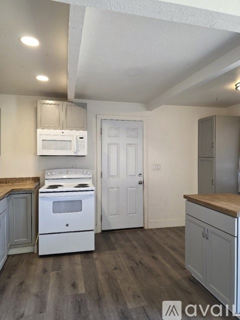 A kitchen with a white oven and microwave.