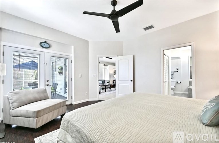 A bedroom with a large bed and a ceiling fan.