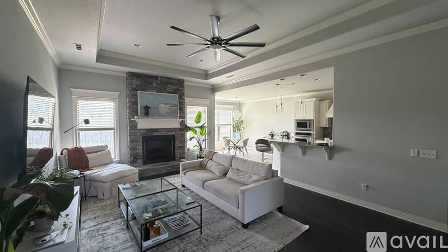 A living room with a fireplace and a glass coffee table.