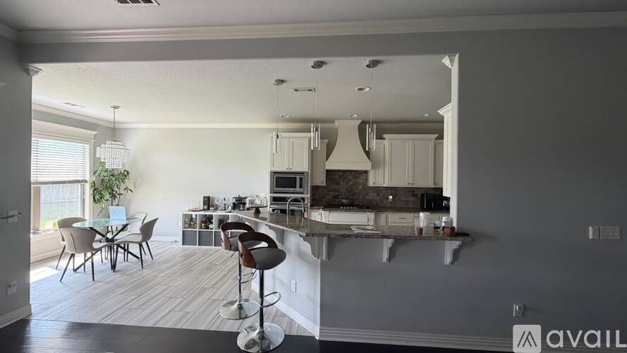A modern kitchen with a bar stool in front of it.