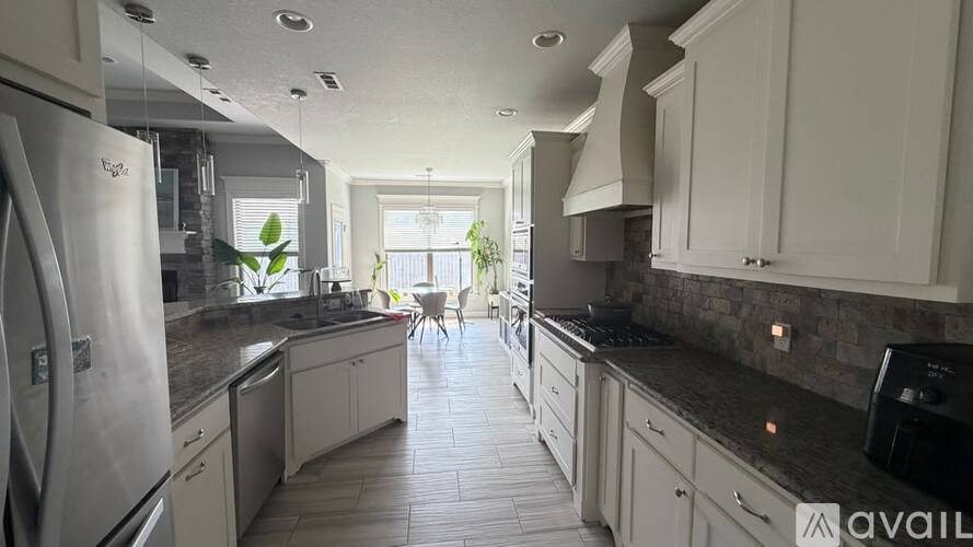A kitchen with white cabinets and a black countertop.
