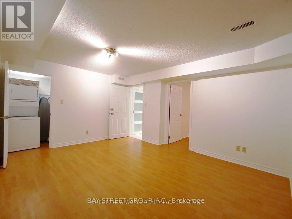 A spacious room with wooden flooring and white walls.