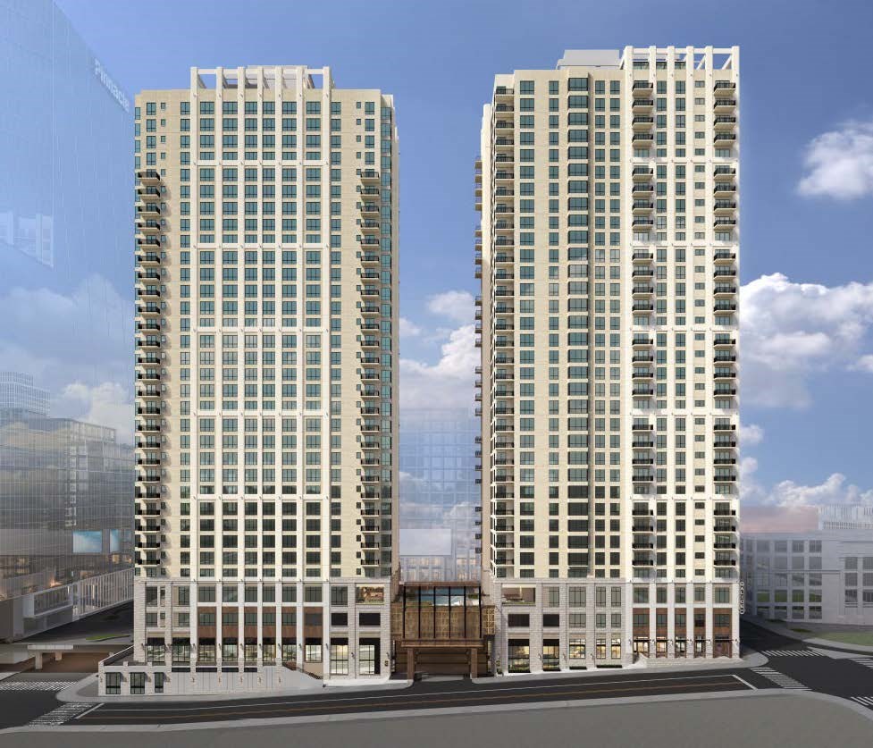 Two modern high-rise buildings with balconies and a cloudy sky in the background.