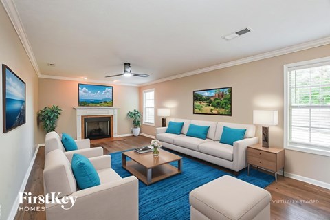 A living room with a fireplace and a painting of a beach scene on the wall.