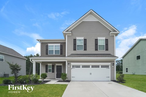 A two-story house with a garage is showcased in the image.