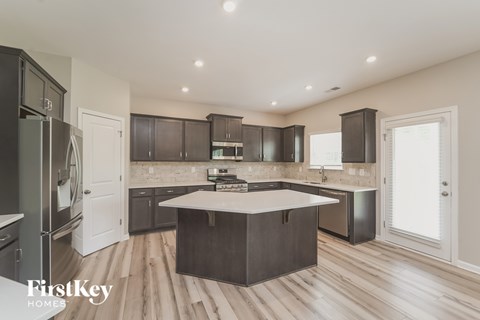 A modern kitchen with dark wood cabinets and a white island.