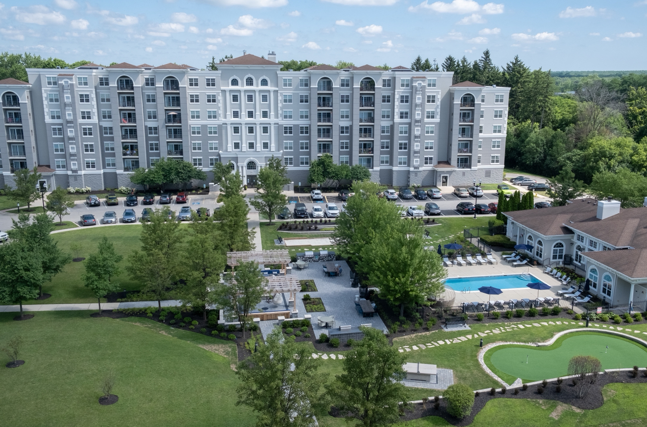 A large apartment complex with a pool and a golf course.