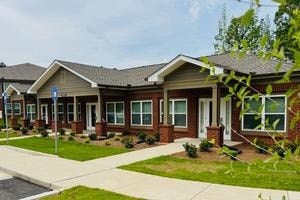 A row of houses with a blue sign on the first one.