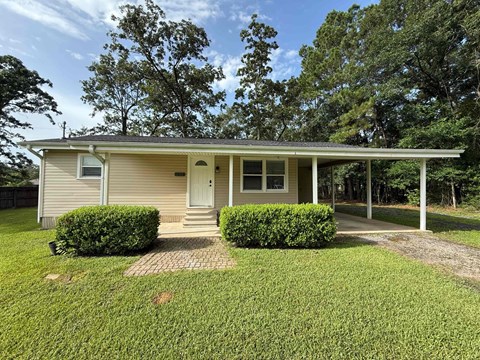 A house with a white front porch and a brown roof.