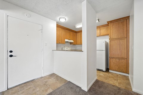 A kitchen with wooden cabinets and a white refrigerator.