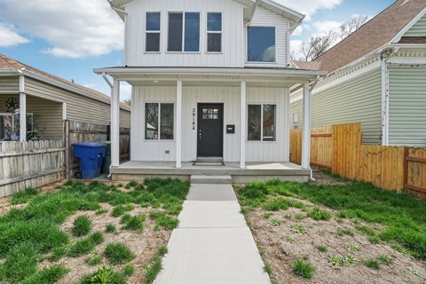 A white house with a black door and a small porch.