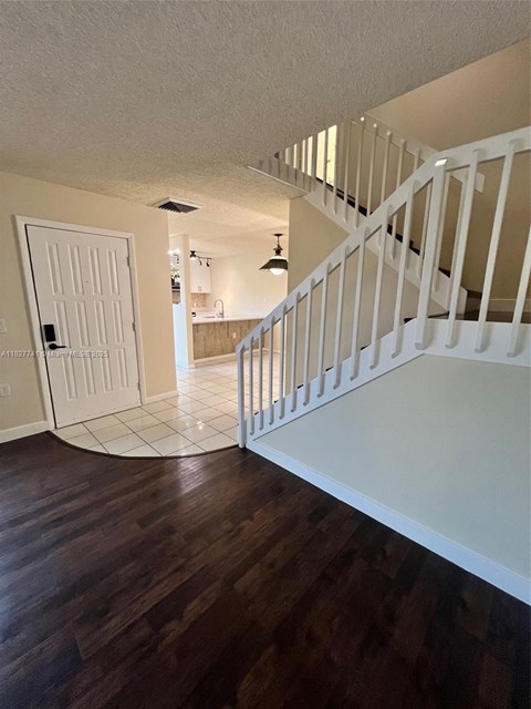 A white staircase with a white door and a white wall.