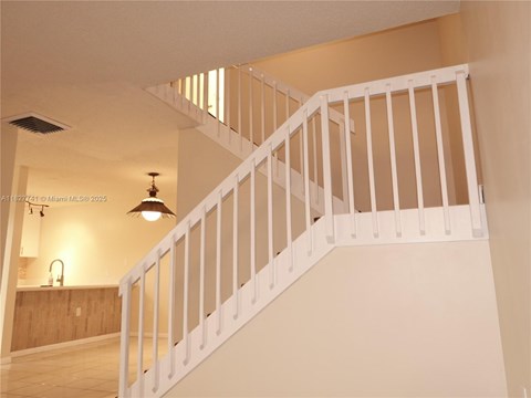 A white staircase with a light on the side.