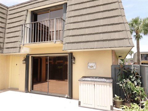 A house with a balcony and a small garden.