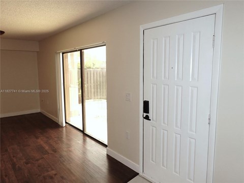 A white door is in a room with a sliding glass door.