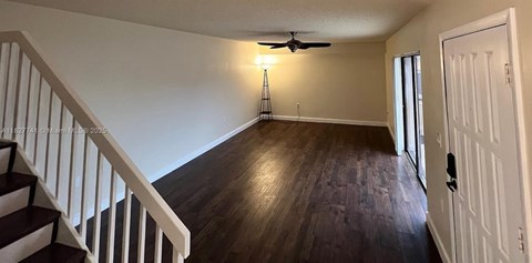 A room with a staircase and a ceiling fan.