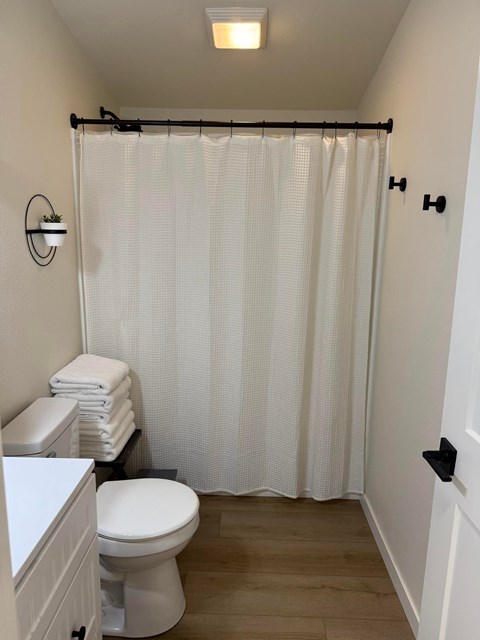 A white toilet sits next to a white sink in a small bathroom.