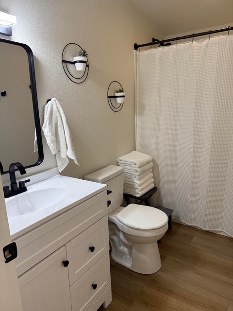 A white toilet sits next to a white sink in a bathroom.