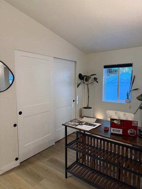 A white door with a black handle and a round mirror on the wall.