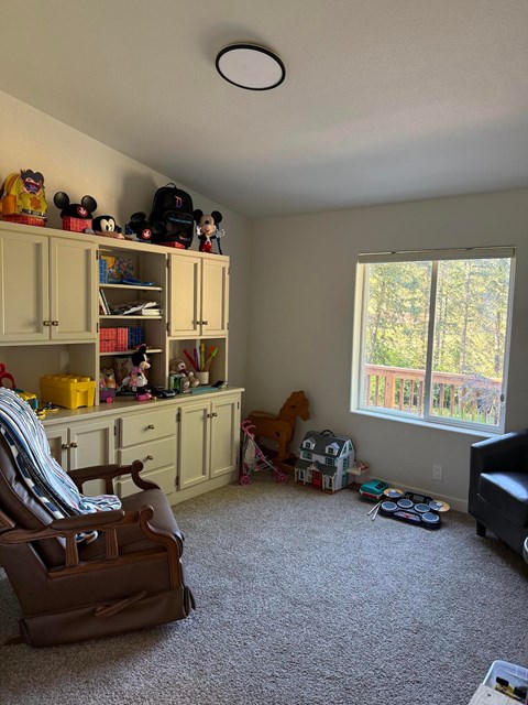 A room with a brown chair and a brown suitcase.