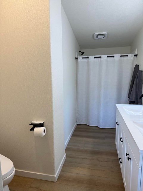 A white toilet is next to a white sink in a small bathroom.