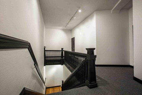 A staircase with a black railing and wooden steps.