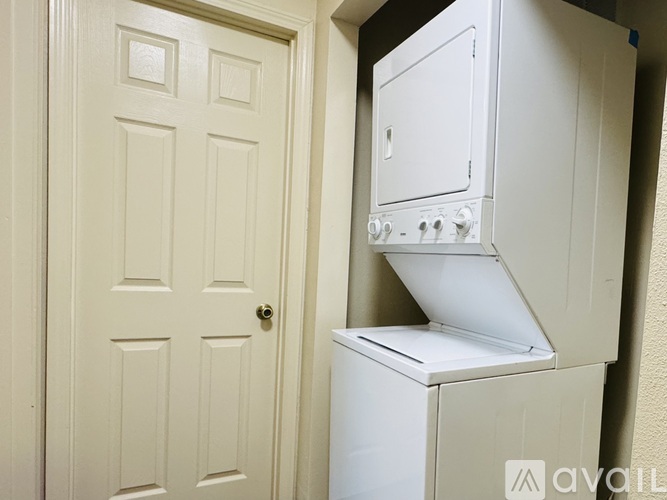 A white fridge in a room with a white door.