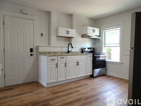 A kitchen with white cabinets and a granite countertop.