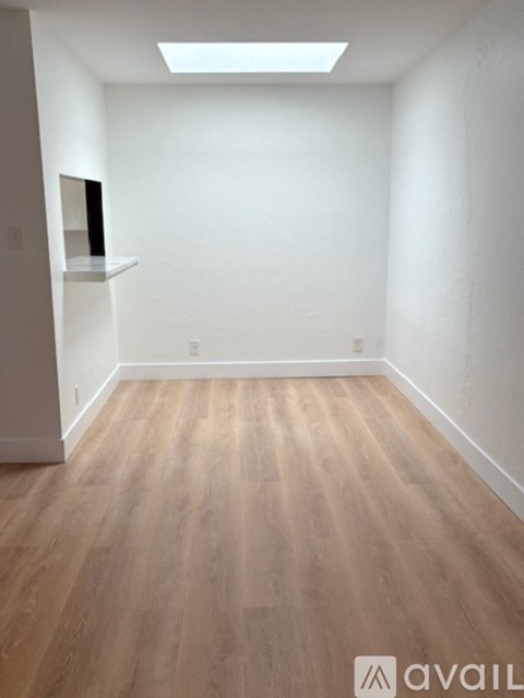 A room with wooden flooring and a skylight.