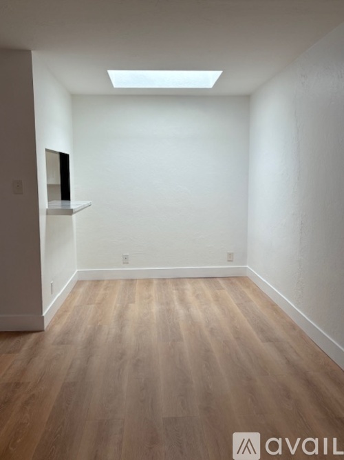 A room with wooden flooring and a skylight.
