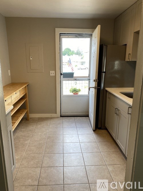 A kitchen with a refrigerator, a counter, and a window.