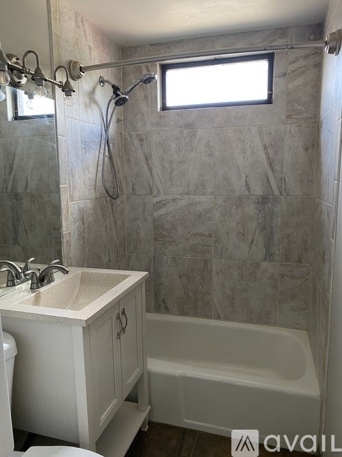 A bathroom with a white sink and a white bathtub.