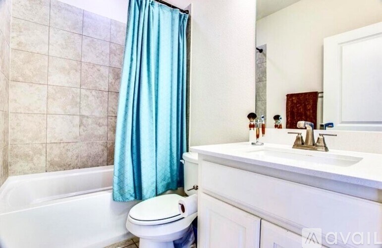 A bathroom with a white tub, toilet, and sink.