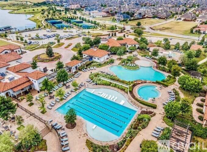 An aerial view of a resort with a swimming pool and a large swimming pool with lanes.