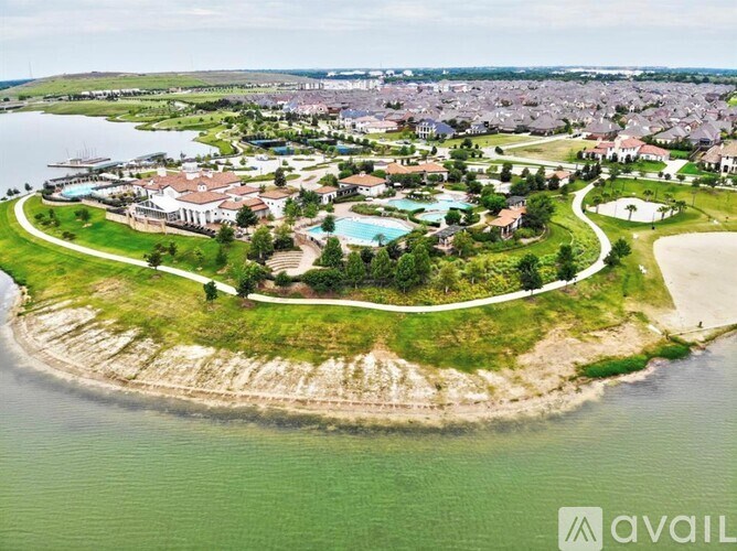 A bird's eye view of a resort with a large swimming pool and a sandy beach.