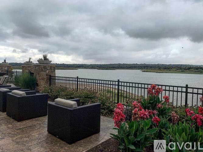 A patio with wicker furniture overlooking a body of water.