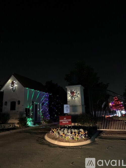 A white building with a lit up Christmas tree in front of it.