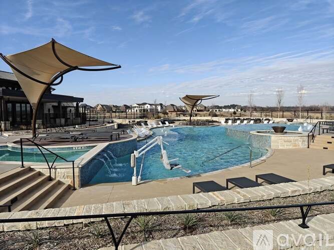 A large outdoor swimming pool with a slide and sun shades.