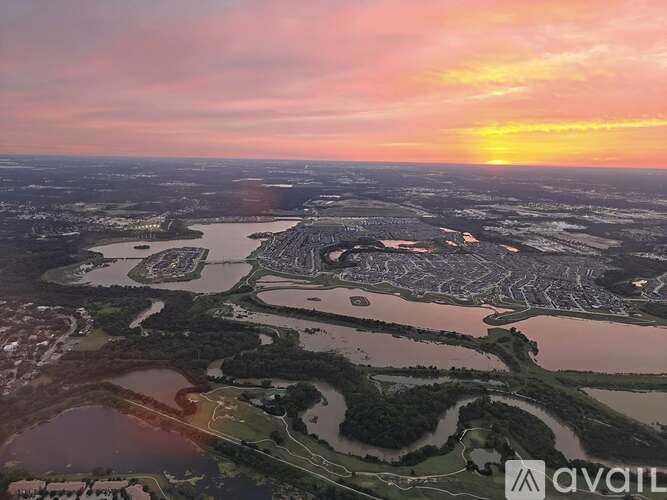 A sunset view of a large body of water with a landmass in the distance.