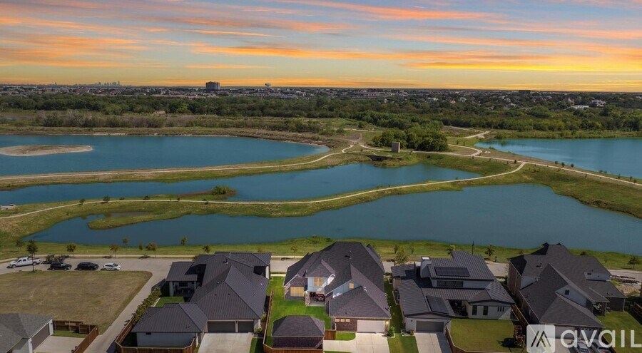 A bird's eye view of a residential area with houses and a lake.