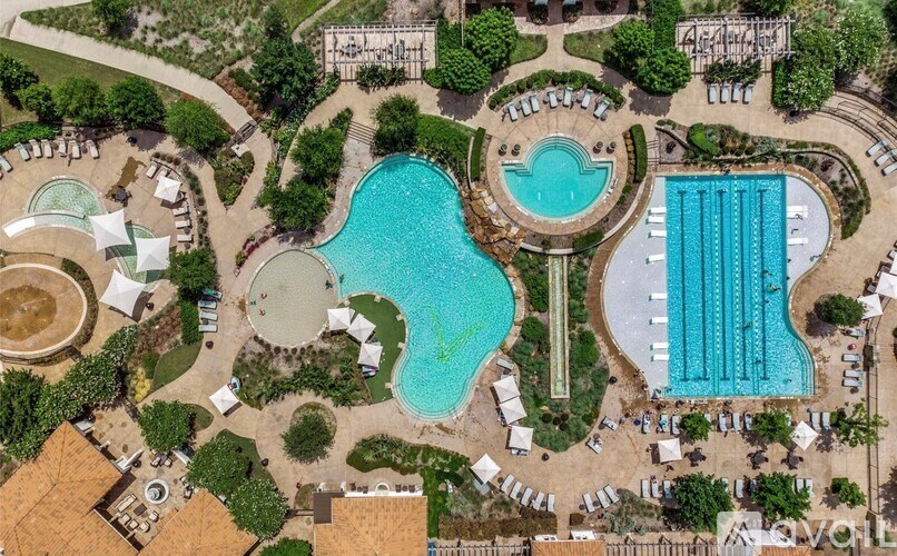 An aerial view of a resort with a large swimming pool and a smaller pool with a waterfall.