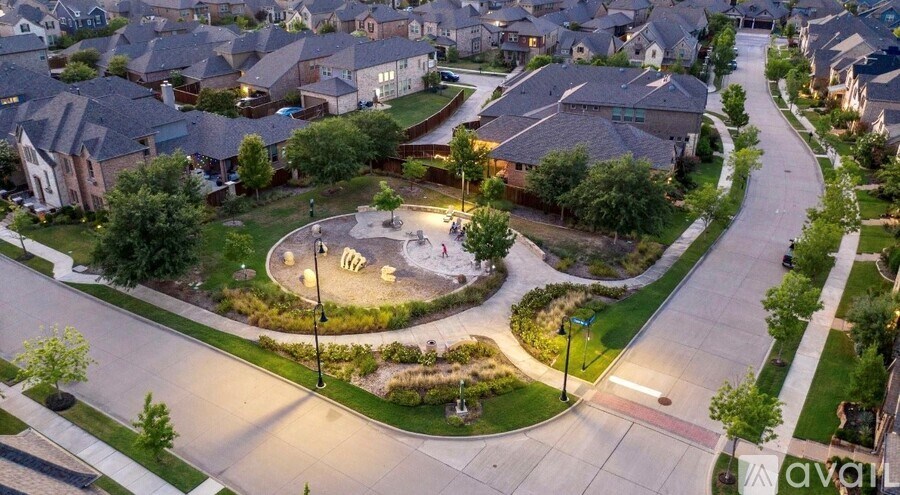 A park in a residential area with a playground and street lights.