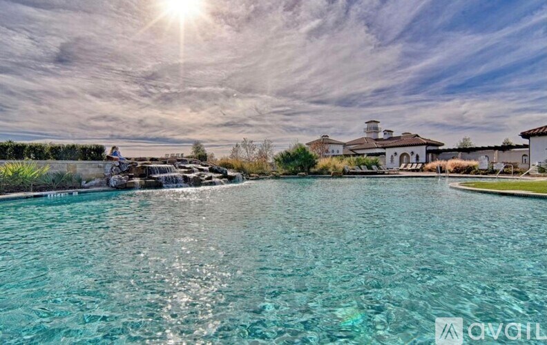 A large swimming pool with a house in the background.