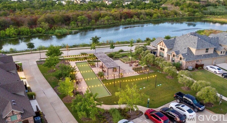 A river flows through a residential area with houses and a park.