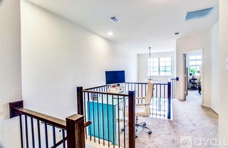 A room with a blue screen and a balcony with a railing.